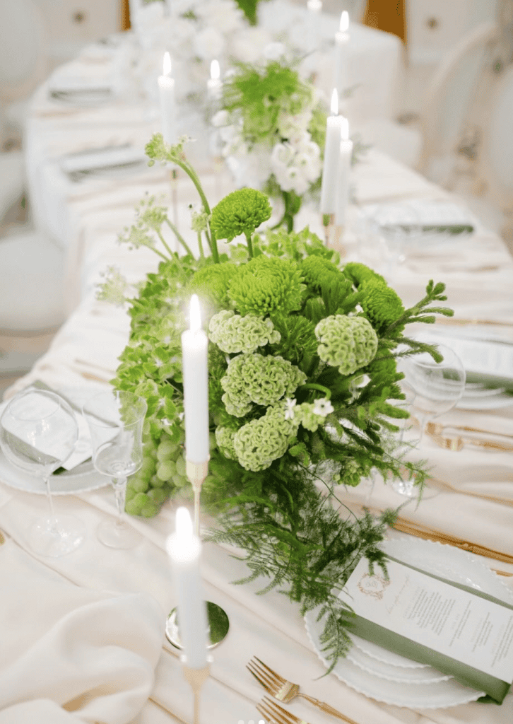 Elegant floral table centerpiece with white and green flowers for wedding or event decoration.