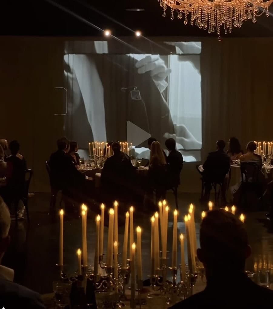 Elegant event with candlelit tables and a large screen projection at UpEventi.