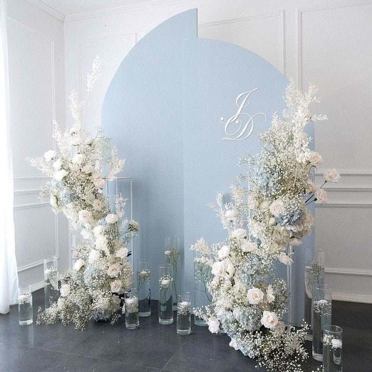 White floral wedding backdrop with blue panel and elegant monogram decor.