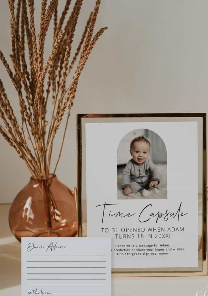 Cute baby boy age 1 on birthday celebration with Time Capsule sign and letter, indoor decor and dried flowers in rose gold vase alt text.