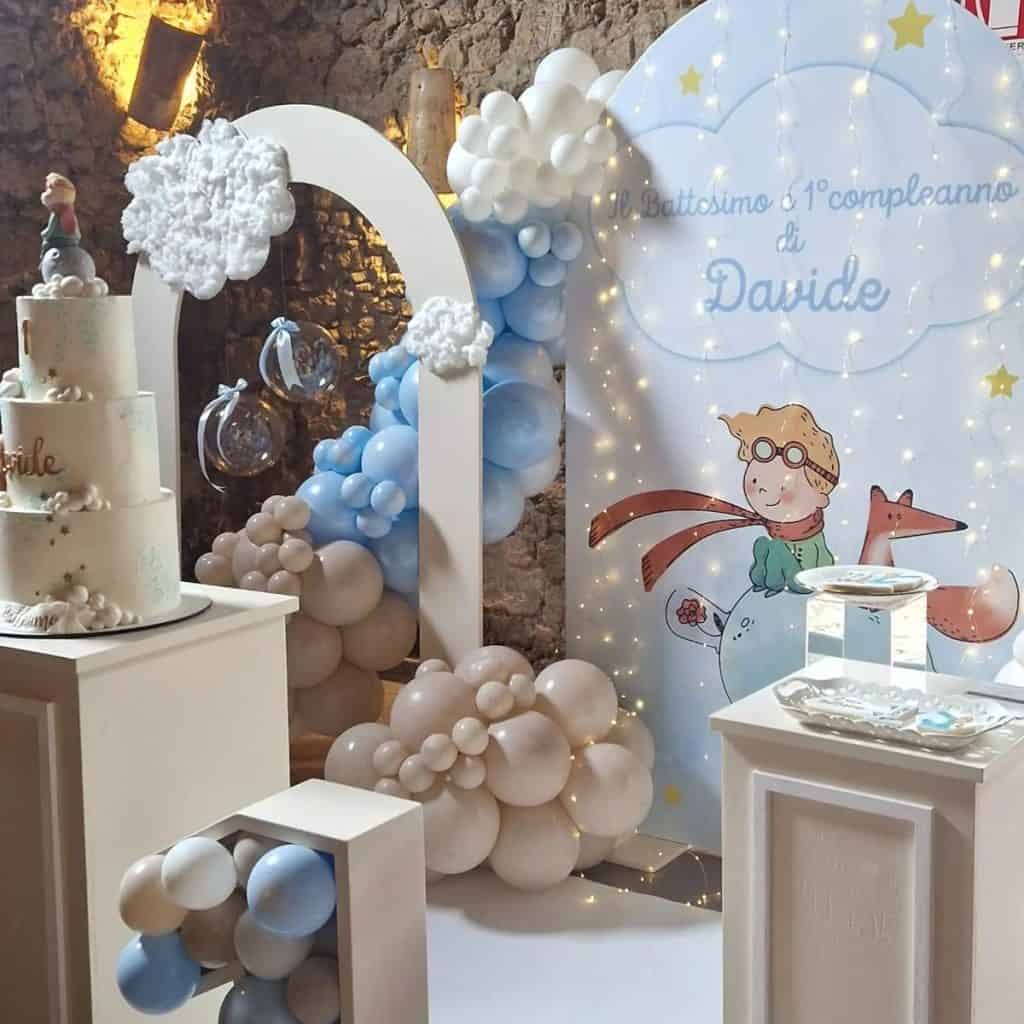 Balloon decoration for child's first birthday celebration with clouds, stars, and a whimsical illustration.