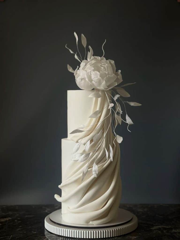 Elegant white wedding cake with floral decoration, perfect for special events and celebrations.