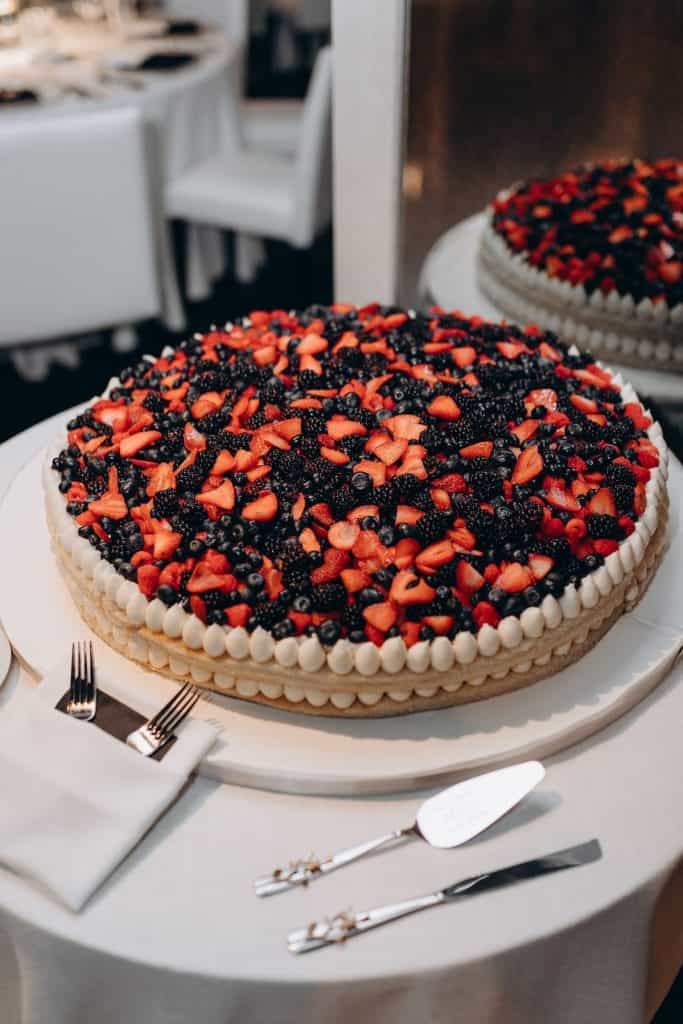 Fresh berry-topped celebration cake at UpEventi event.
