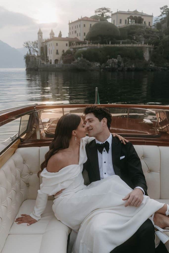 Luxurious couple enjoying a private boat ride on Lake Como with scenic villas in the background.