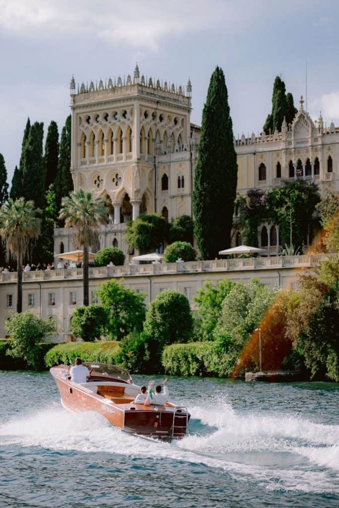 Elegant historic Italian palace surrounded by lush greenery and cypress trees.