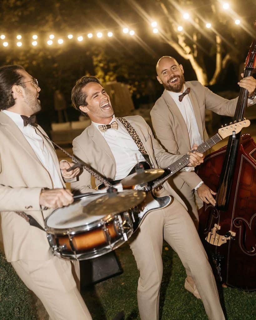 Playing live jazz band with string instruments and drums at outdoor event, enjoying festive night celebration.