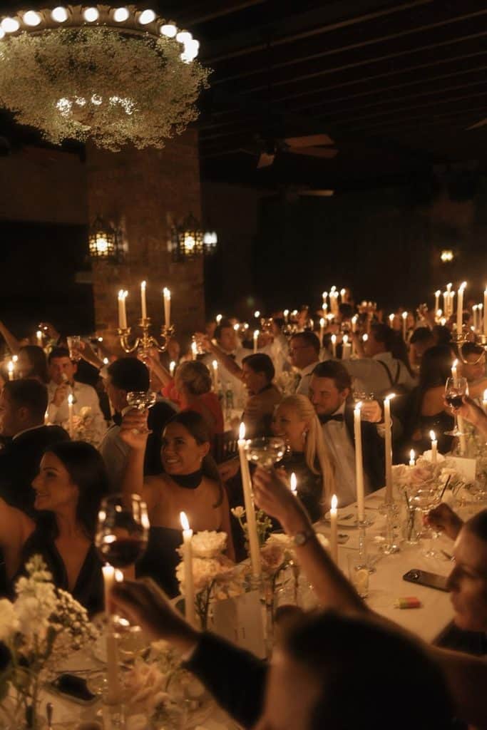 Celebration event with guests raising glasses in a decorated, candlelit dinner setting at UpEventi.