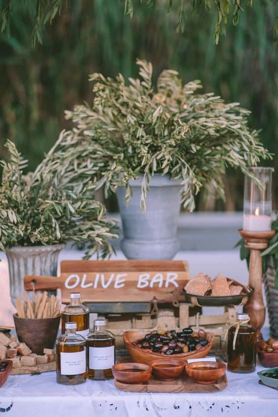 Vibrant outdoor olive bar display with fresh herbs and Mediterranean snacks for event catering.