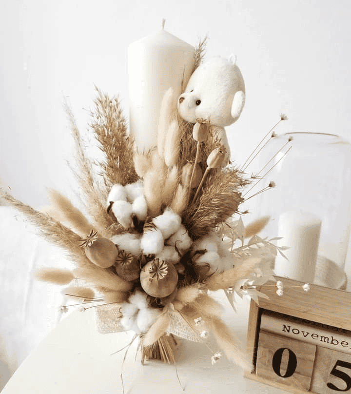 Rustic dried flower bouquet with teddy bear and candles for event decor.