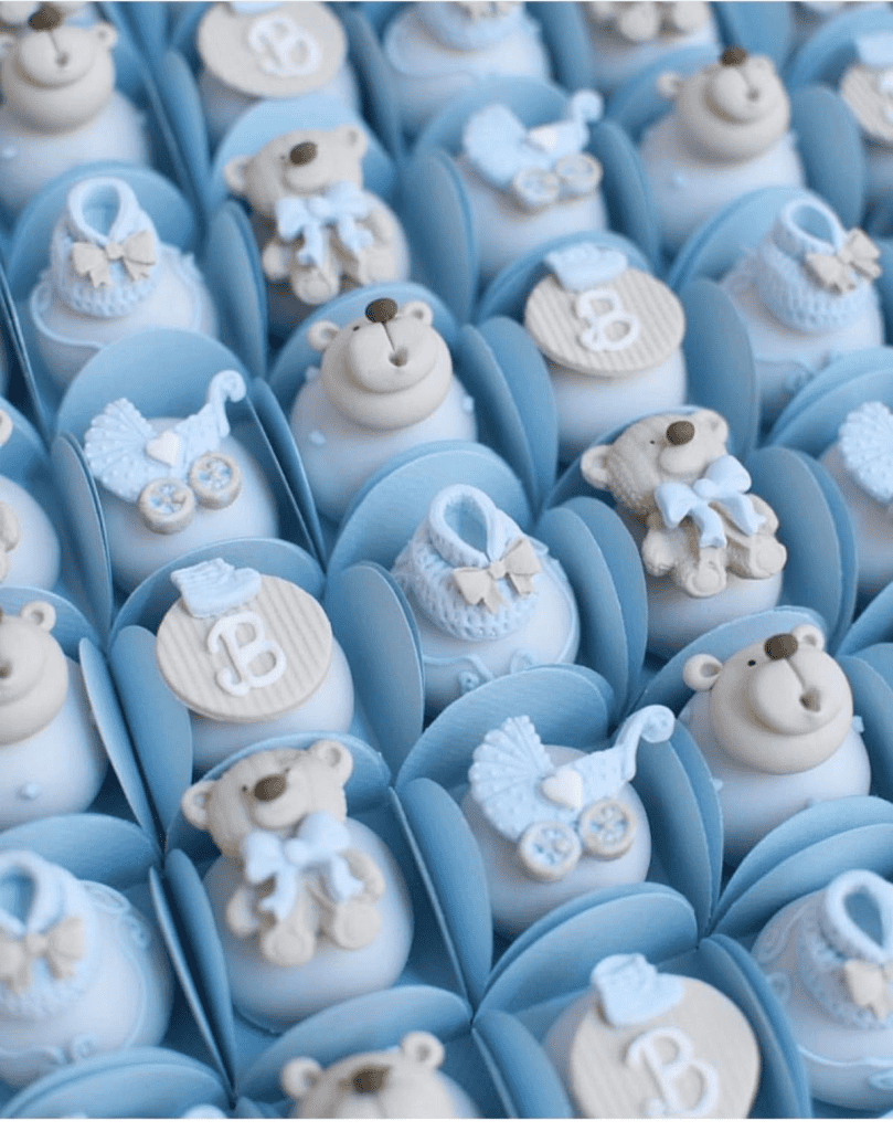 Cream-colored teddy bear and baby-themed cupcake decorations in blue fondant.