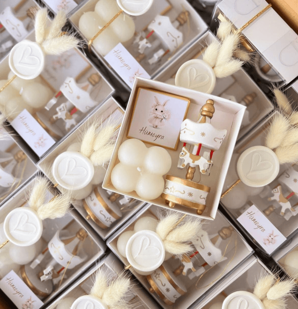 Beautiful white and gold baby gift set with bunny details, candles, and decorative elements, perfect for special occasions.